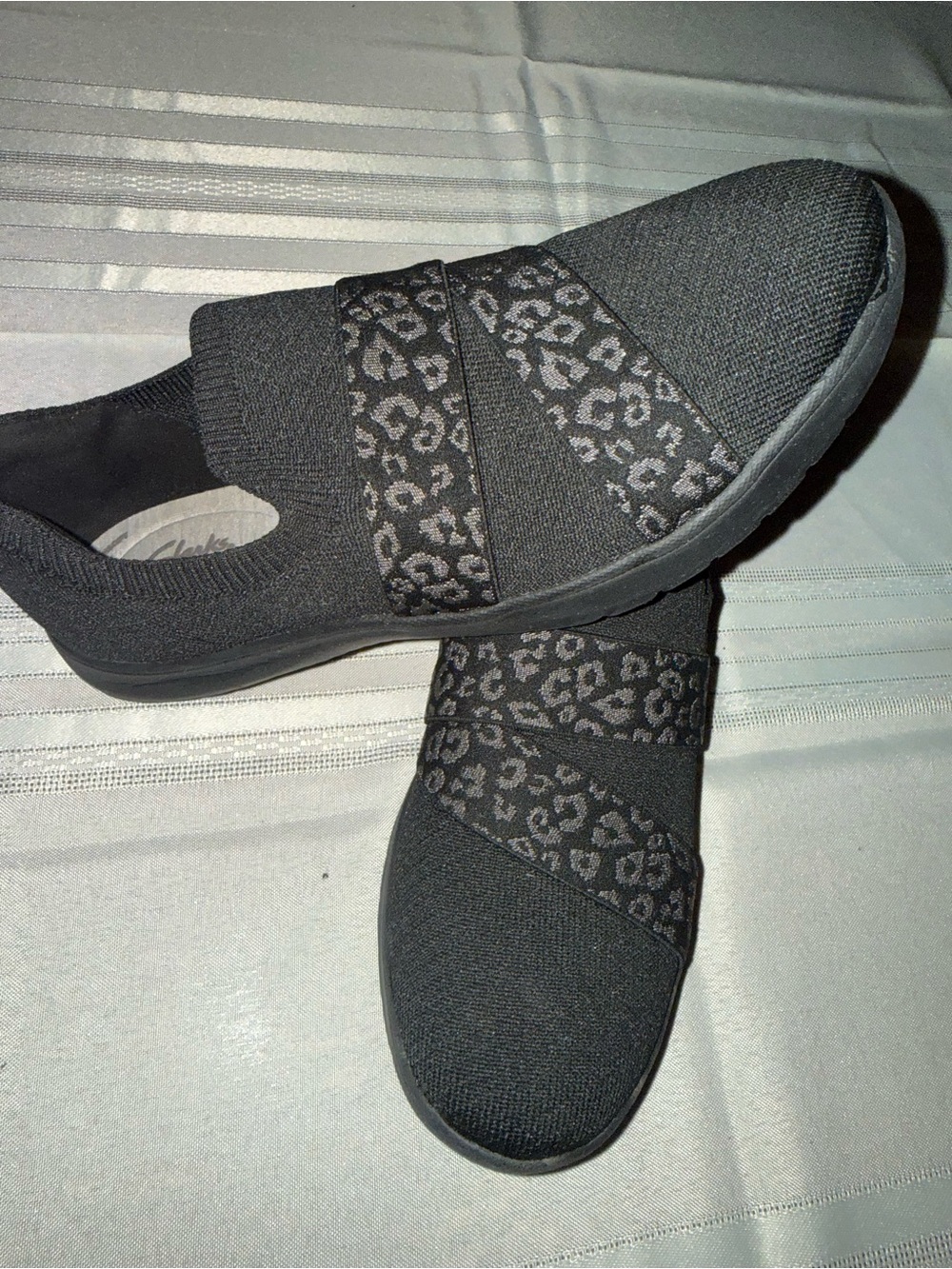 Clarks cloud steppers Women’s Black Slip-On Knit Sneakers  Leopard-Print Strap